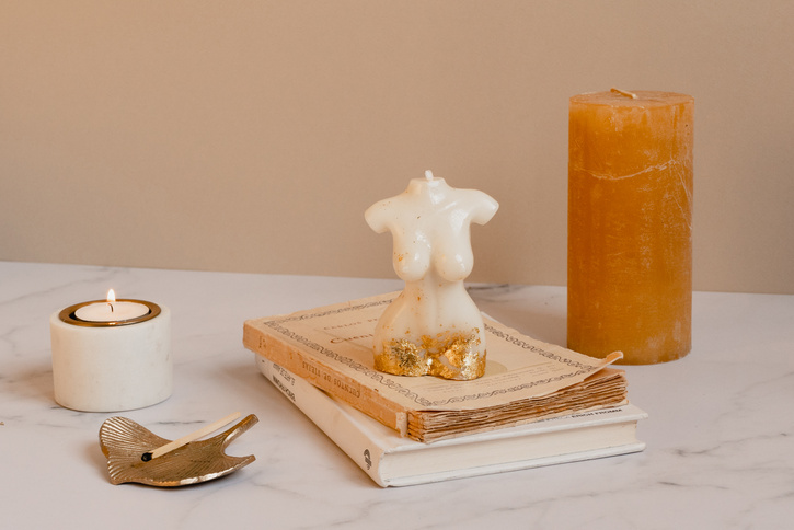 Body Shaped and Brown Candles on Marble Background